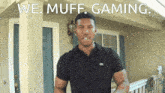 a man in a black shirt stands in front of a house with the words we muff gaming