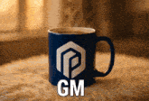 a blue coffee mug with the word gm on the front