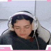 a woman wearing headphones is laying down with her eyes closed