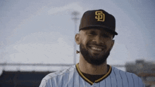 a man with a beard wearing a baseball cap and smiling .