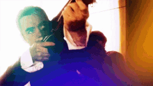 a man in a suit is holding a gun