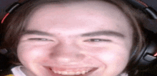 a close up of a person 's face wearing headphones and smiling