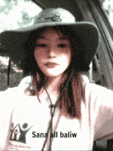 a woman wearing a hat and a shirt with sana all baliw on it