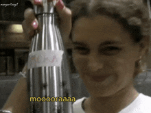 a woman is holding a bottle of vodka and says mooooraaaa
