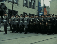 a group of soldiers are lined up in front of a building with a banner that says ' polizei ' on it