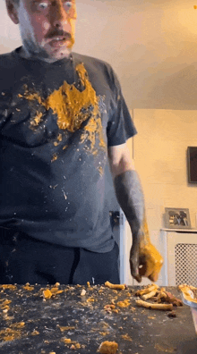 a man with a tattoo on his arm is standing in front of a table covered in food
