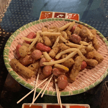 a plate with french fries and sausages on sticks