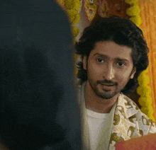 a man with long hair and a beard looks at someone