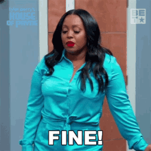 a woman in a blue shirt is standing in front of a door and says fine !