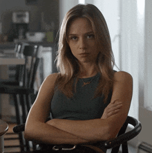 a woman sitting in a chair with her arms crossed and a necklace that says julia