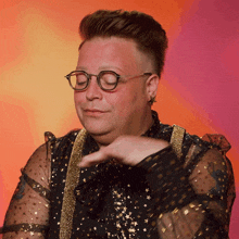 a man wearing glasses and a black top with gold stars on it