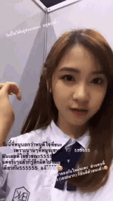 a girl in a white shirt with a blue tie is looking at the camera with a message in a foreign language