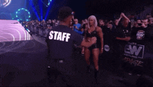 a woman is kneeling down in front of a sign that says aew