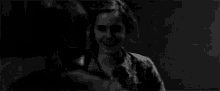 a black and white photo of harry potter laughing while holding someone 's hand .