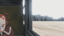 a girl with a cat mask on her face sits in a chair looking out a window
