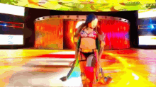 a woman in a bikini is standing on a stage in front of a colorful background .