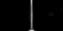 a man in a white robe is standing in front of a door in a dark room .