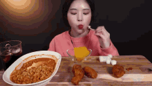 a woman is sitting at a table with a bowl of food and a bowl of sugar cubes