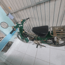 a green honda motorcycle is parked on the tiled floor
