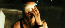 a man with a bandage on his eye covering his eyes