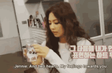 a woman is holding a glass and says jennie and two hearts
