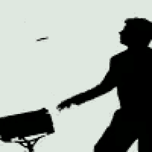a silhouette of a man standing in front of a camera with his hand outstretched .