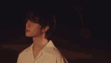 a group of young men with pink hair are standing next to each other on a beach at night .