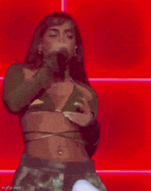 a woman in a green bikini top is singing into a microphone .