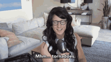 a woman in a wig is holding a spoon and says mhm tornadoes