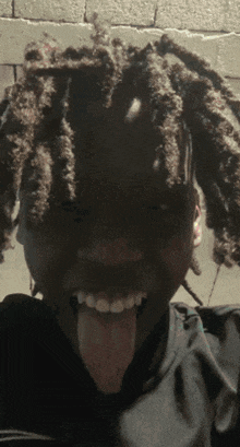 a man with dreadlocks sticking his tongue out