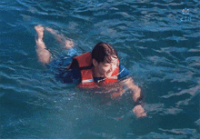 a man in a life jacket is swimming in a pool
