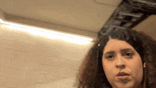 a woman with curly hair is making a face