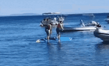 a group of people are standing on a paddle board in the ocean