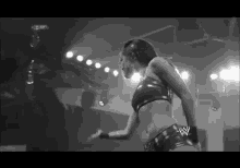 a black and white photo of a woman in a wrestling outfit .
