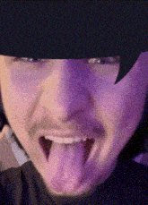 a close up of a man sticking his tongue out .