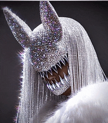 a woman wearing a mask with rhinestones and long hair