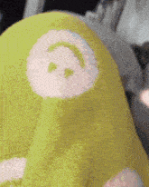 a close up of a green blanket with a smiley face on it