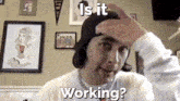 a man scratching his head with the words " is it working " behind him
