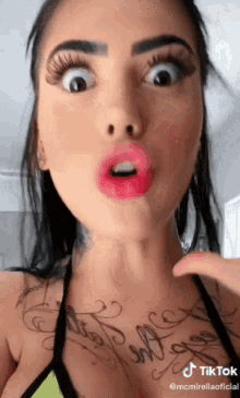 a woman with a tattoo on her chest is making a face