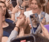 a group of people are taking a selfie with their phones .