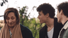 two men and a woman are standing next to each other and talking
