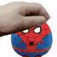 a hand is holding a stuffed spider man toy on top of it .