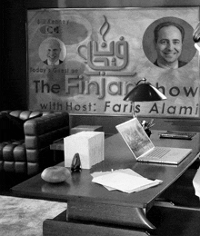 a black and white photo of a desk in front of a sign that says the finjar show