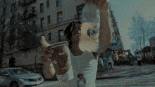 a man in a white tank top is holding a cup of coffee with the word coffee on it