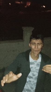 a man in a camouflage shirt is making a funny face with his hands outstretched