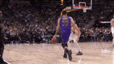 a basketball player with the number 77 on his jersey is dribbling the ball