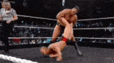 a man is wrestling another man in a wrestling ring .