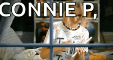 a woman is sitting in front of a window with the words connie p. written on it