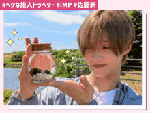 a man is holding a small jar with a cork lid in his hand