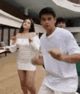 a man and a woman are dancing together in front of a building .